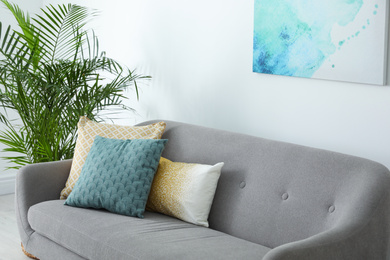 Photo of Different soft pillows on sofa in living room