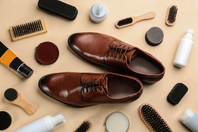 Flat lay composition with shoe care accessories and footwear on beige background