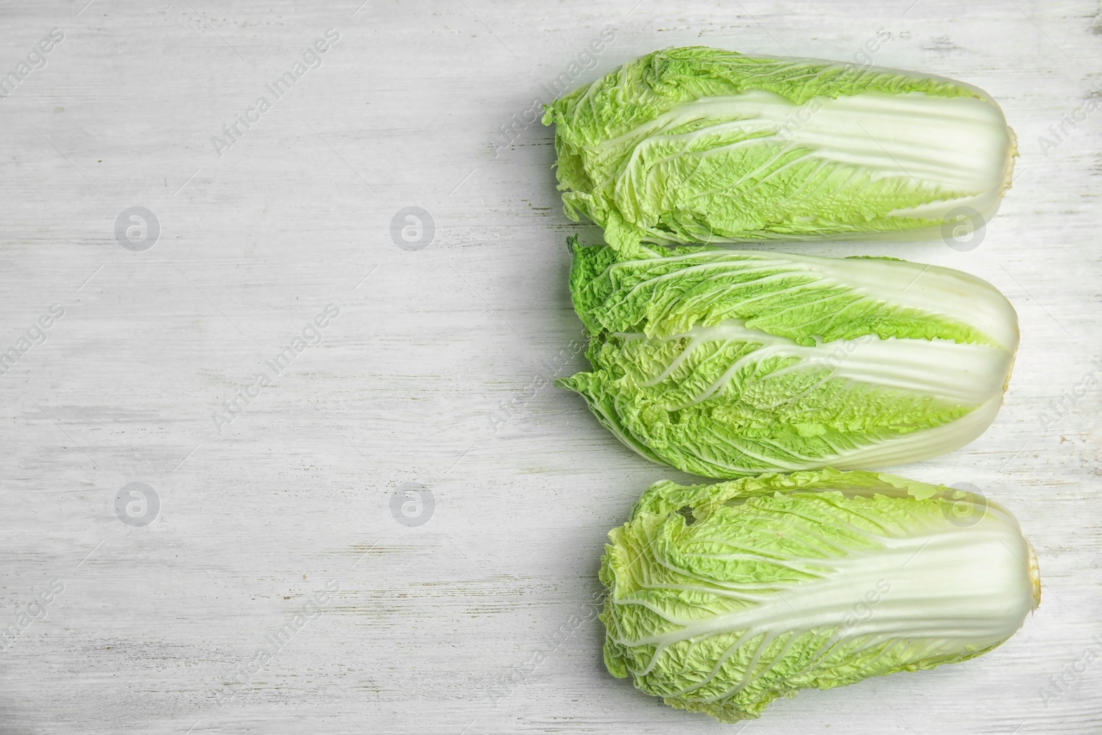 Photo of Fresh ripe cabbages on wooden background, top view