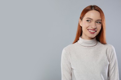 Portrait of beautiful young woman on light gray background, space for text