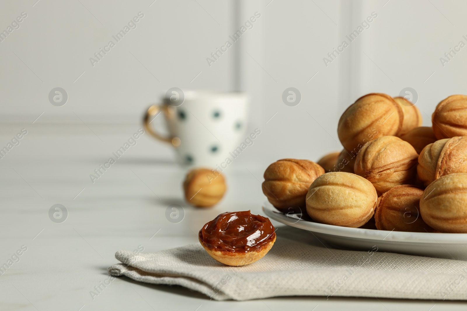 Photo of Homemade walnut shaped cookies with boiled condensed milk on table, space for text