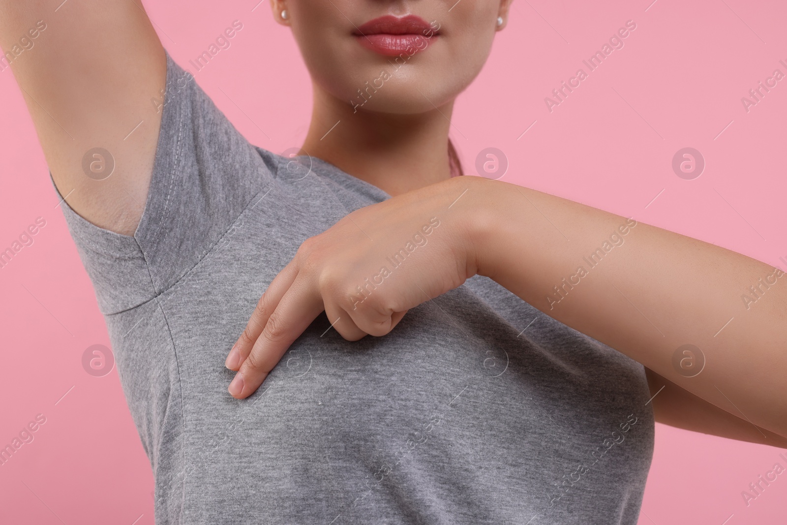 Photo of Woman doing breast self-examination on pink background, closeup