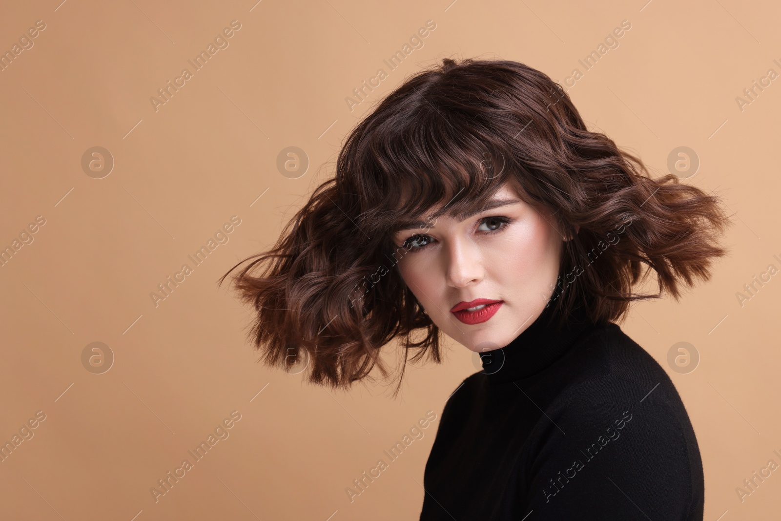 Photo of Portrait of beautiful young woman with wavy hairstyle on beige background. Space for text