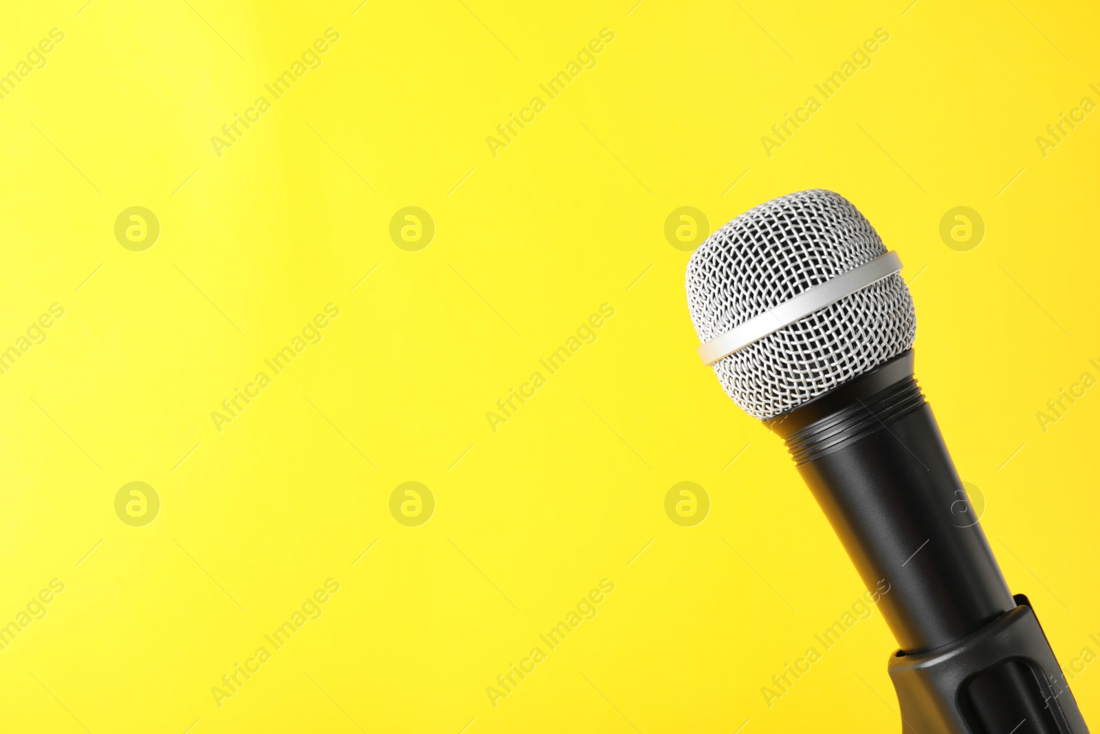 Photo of Dynamic microphone on color background, space for text