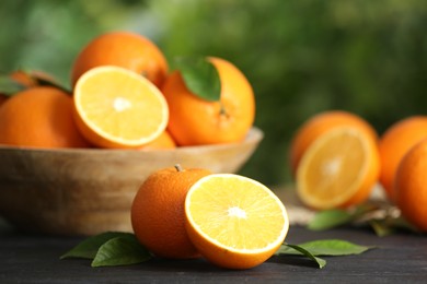 Photo of Fresh ripe oranges on wooden table against blurred background. Space for text