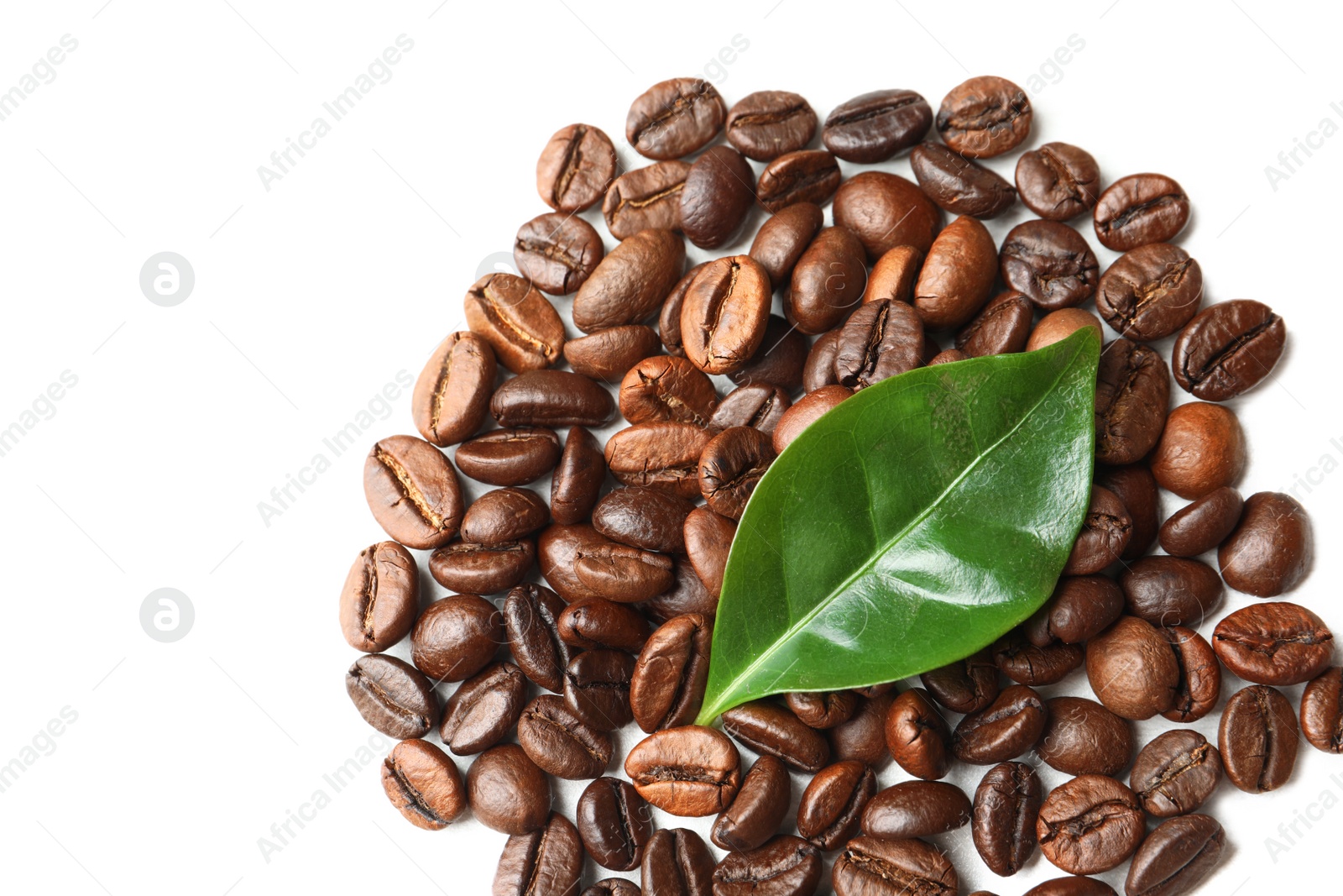 Photo of Roasted coffee beans and green leaf on white background, top view