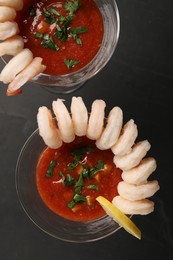 Photo of Tasty shrimp cocktail with sauce in glasses and lemon on grey table, flat lay