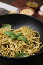 Photo of Delicious pasta with pesto sauce and basil on table, closeup