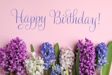 Happy Birthday! Beautiful spring hyacinth flowers on pink background, flat lay