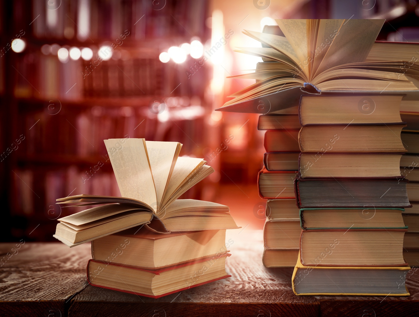 Image of Stacks of different books on wooden table in library