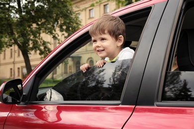 Photo of Little boy alone inside car. Child in danger