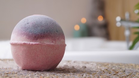 Photo of Beautiful bath bomb on wicker mat in bathroom, closeup. Space for text