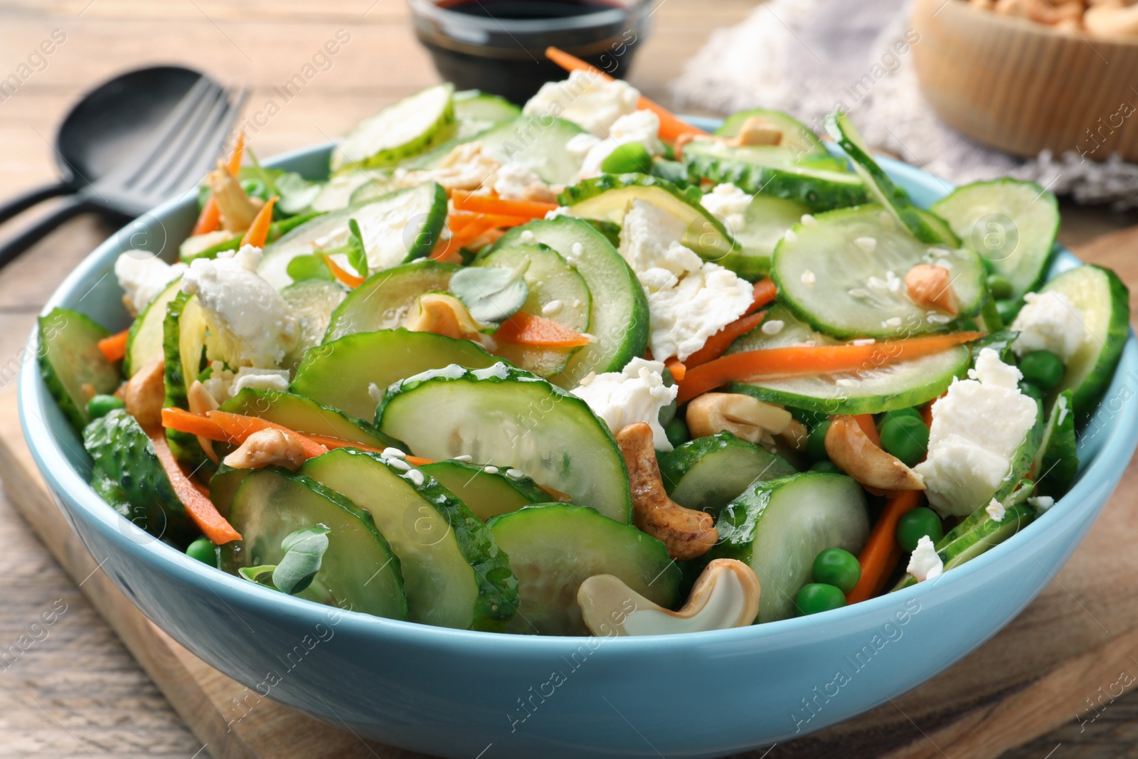 Photo of Delicious cucumber salad on wooden table, closeup