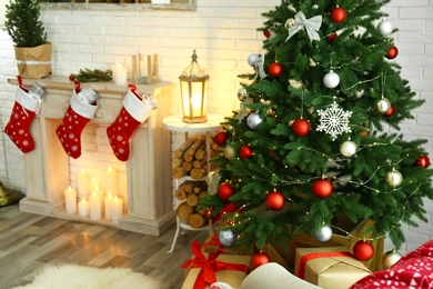 Photo of Stylish interior with beautiful Christmas tree and decorative fireplace