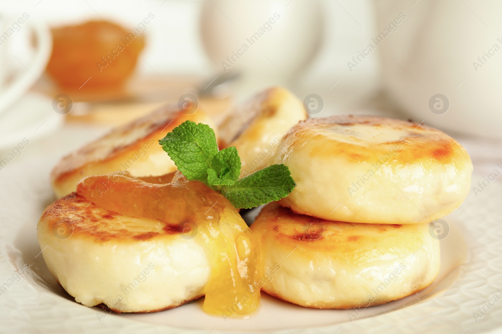 Photo of Delicious cottage cheese pancakes with mint on plate, closeup