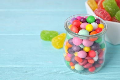 Yummy candies on light blue table, space for text