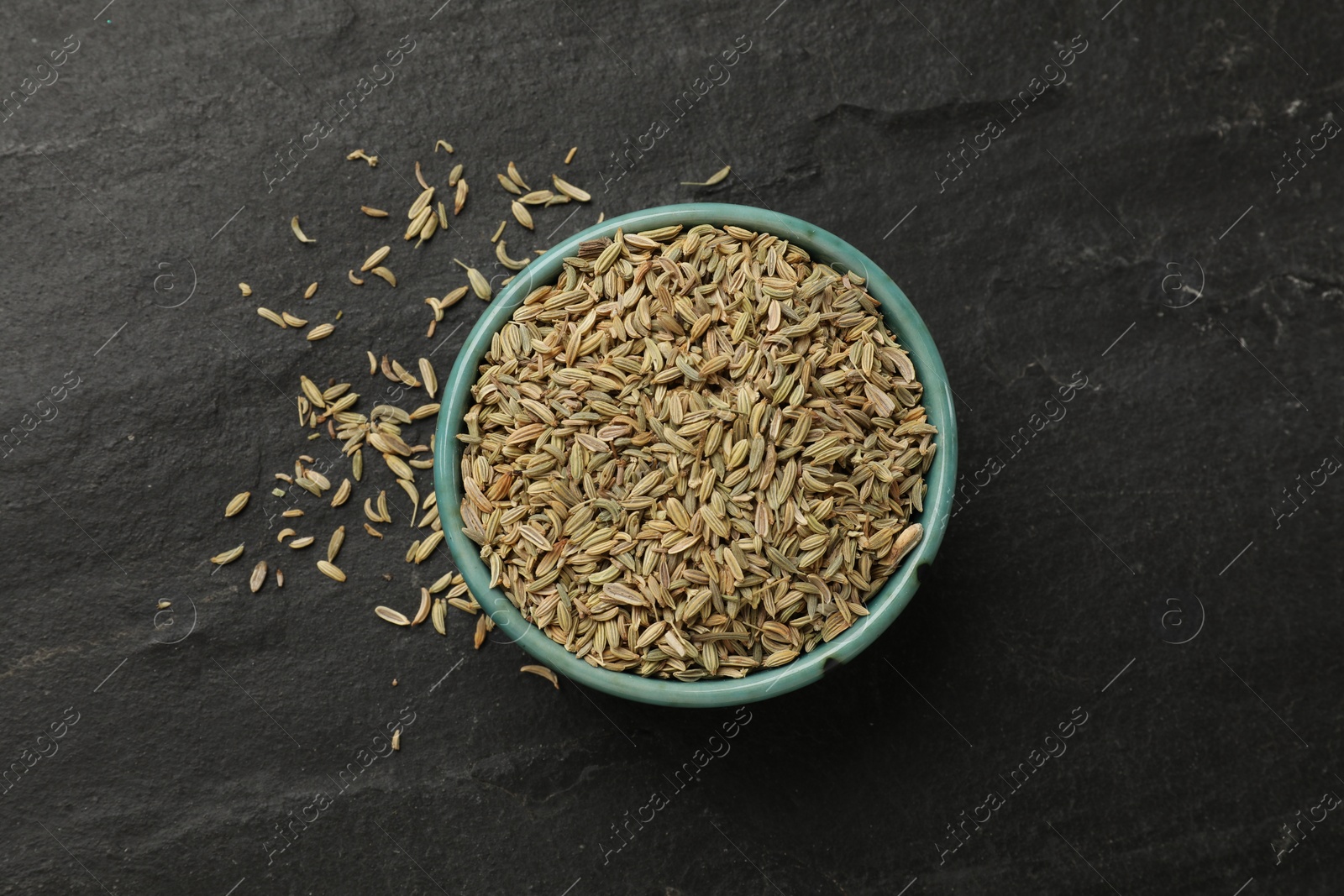 Photo of Fennel seeds in bowl on gray table, top view