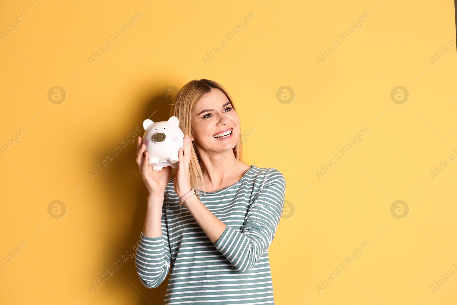 Photo of Woman with piggy bank on color background