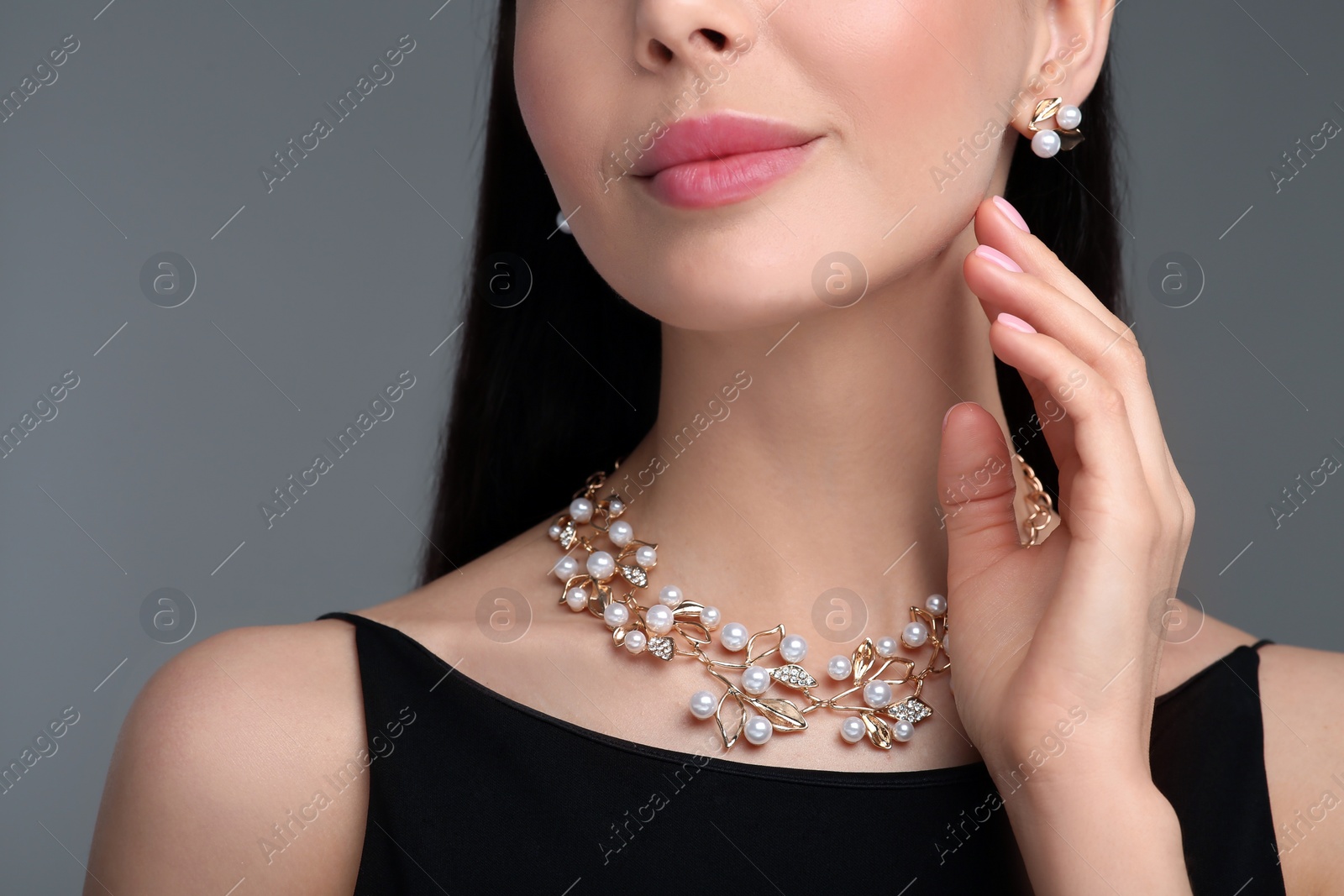 Photo of Young woman with elegant jewelry on dark grey background, closeup