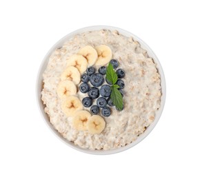 Photo of Tasty boiled oatmeal with banana and blueberries in bowl isolated on white, top view