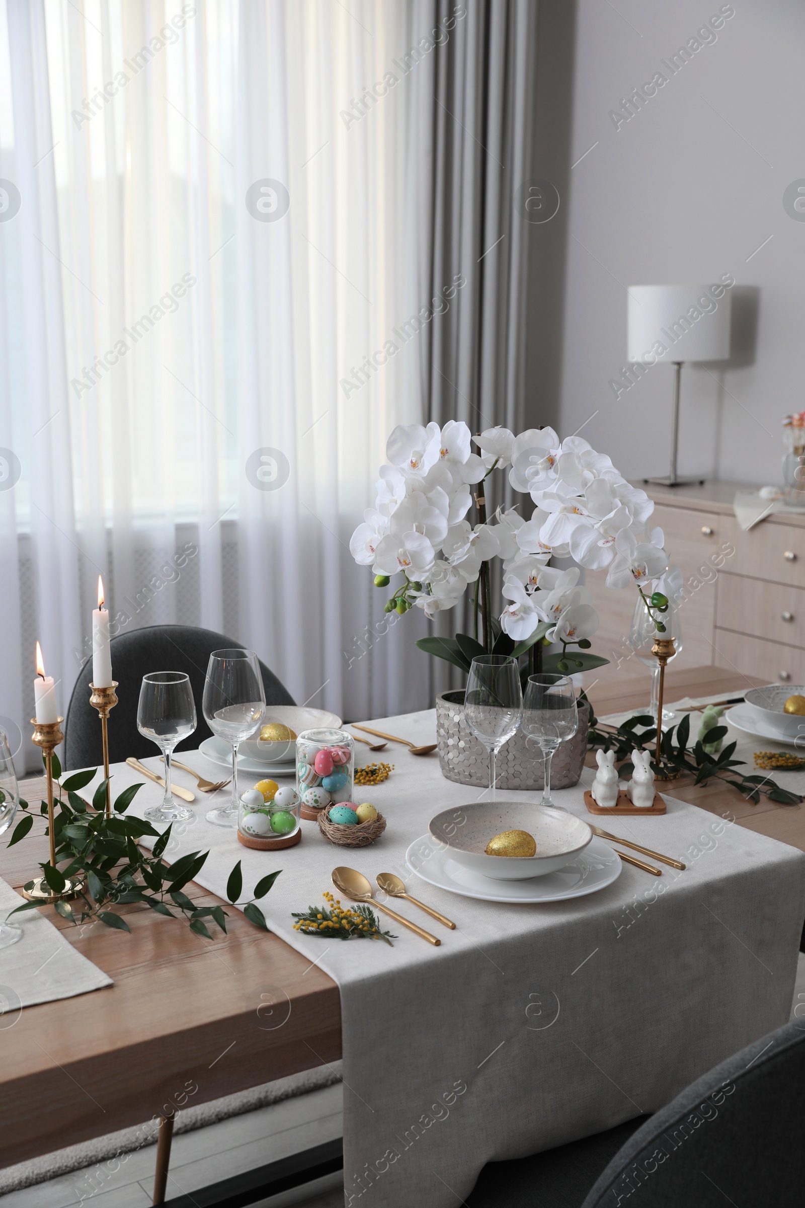 Photo of Beautiful Easter table setting with orchid flowers indoors