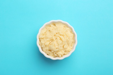 Photo of Bowl with tasty mashed potatoes on color background, top view