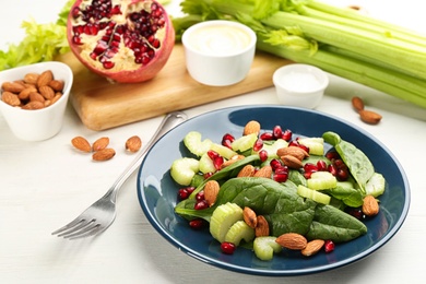 Photo of Delicious fresh celery salad on white wooden table