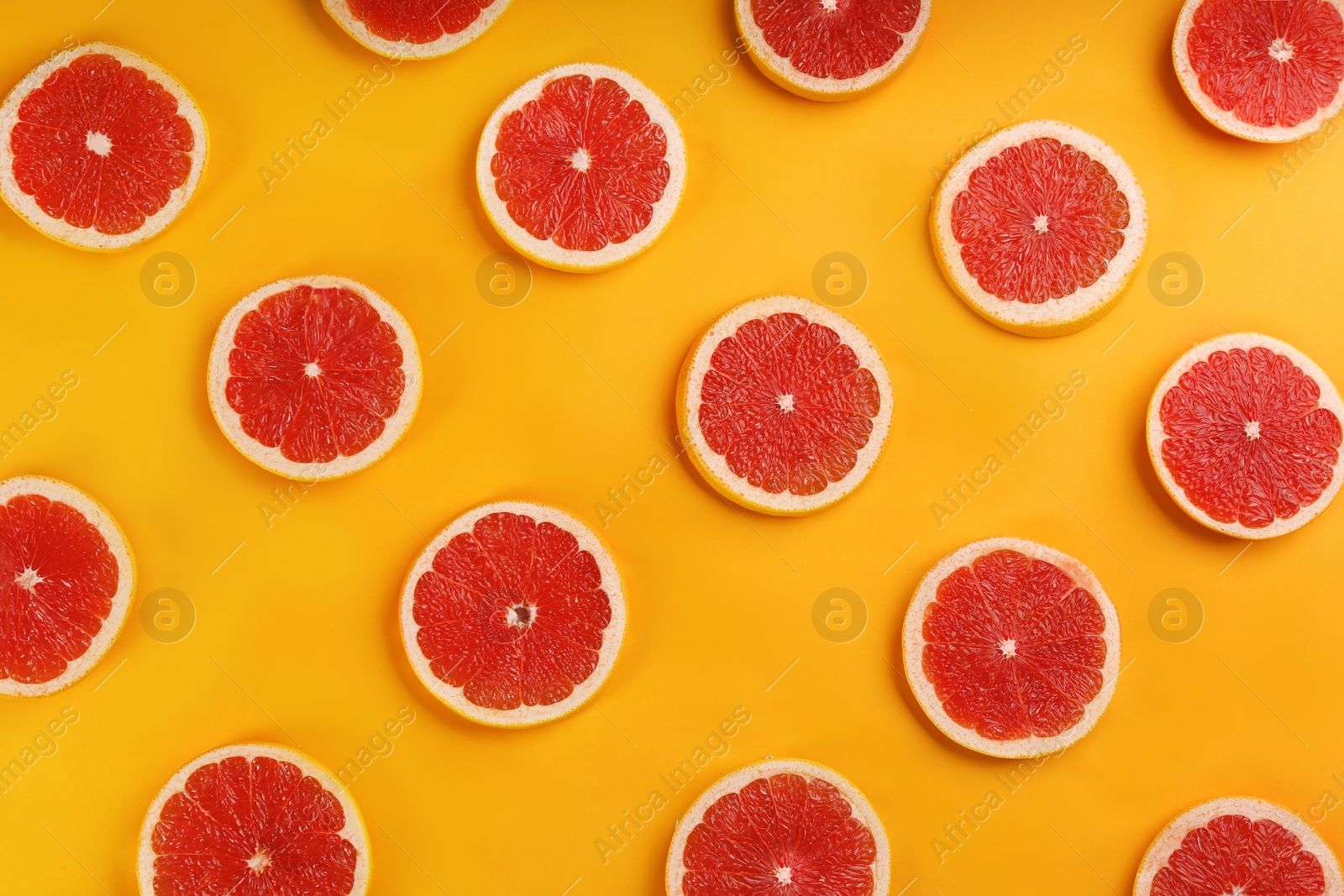 Photo of Flat lay composition with tasty ripe grapefruit slices on orange background