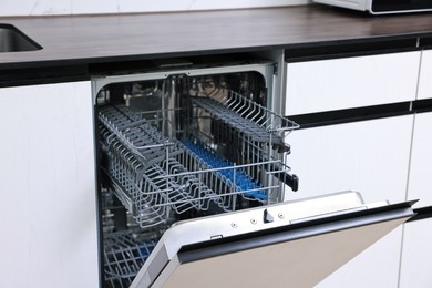 Built-in dishwasher with open door indoors. Home appliance