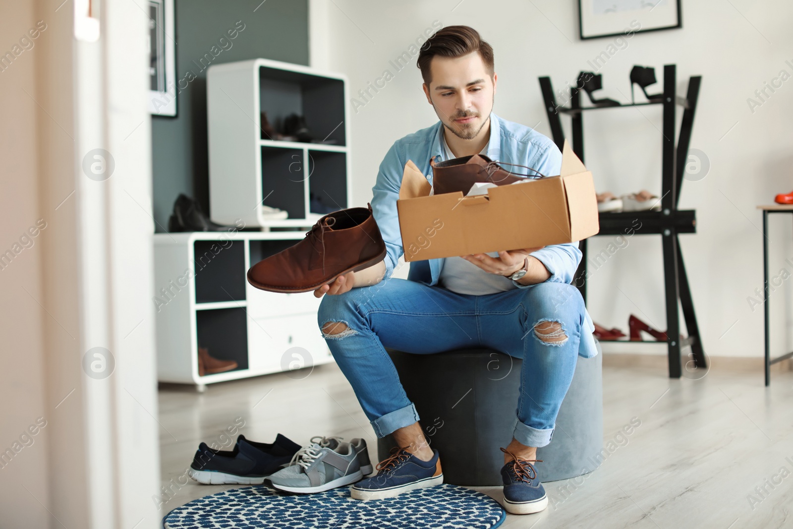 Photo of Young man choosing shoes in store