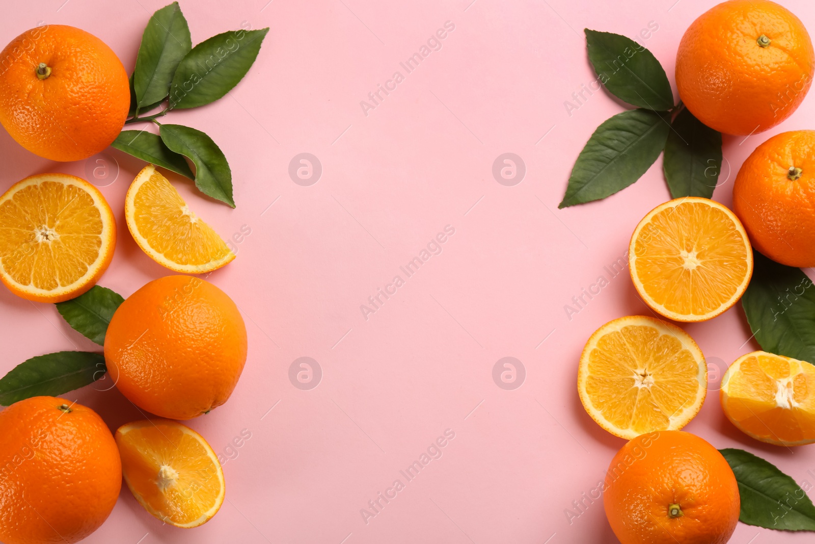 Photo of Fresh ripe oranges with green leaves on pink background, flat lay. Space for text