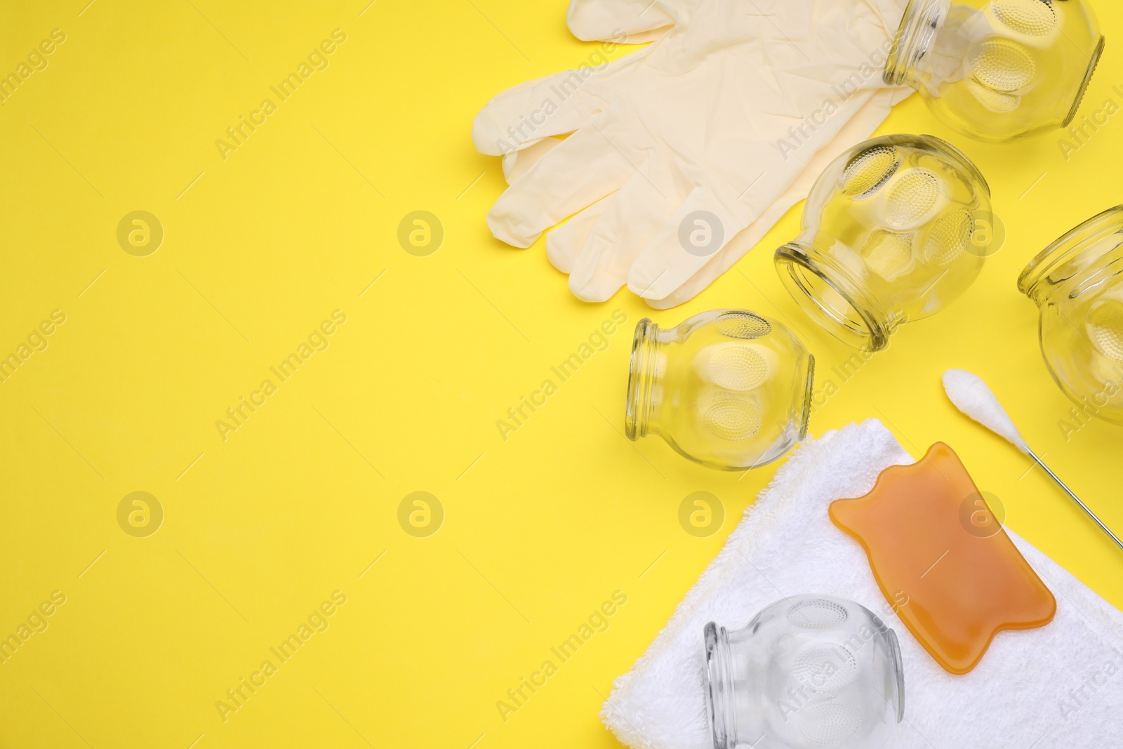 Photo of Flat lay composition with glass cups on yellow background, space for text. Cupping therapy