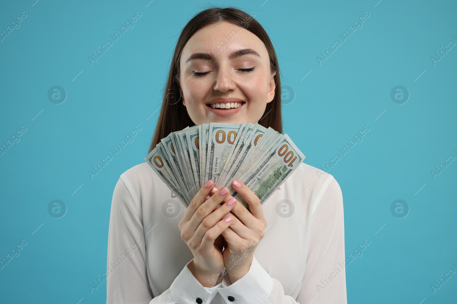 Photo of Happy woman with dollar banknotes on light blue background