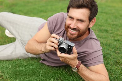 Photo of Man with camera on green grass. Interesting hobby