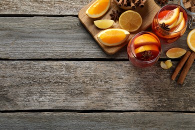 Photo of Aromatic punch drink and ingredients on wooden table, flat lay. Space for text
