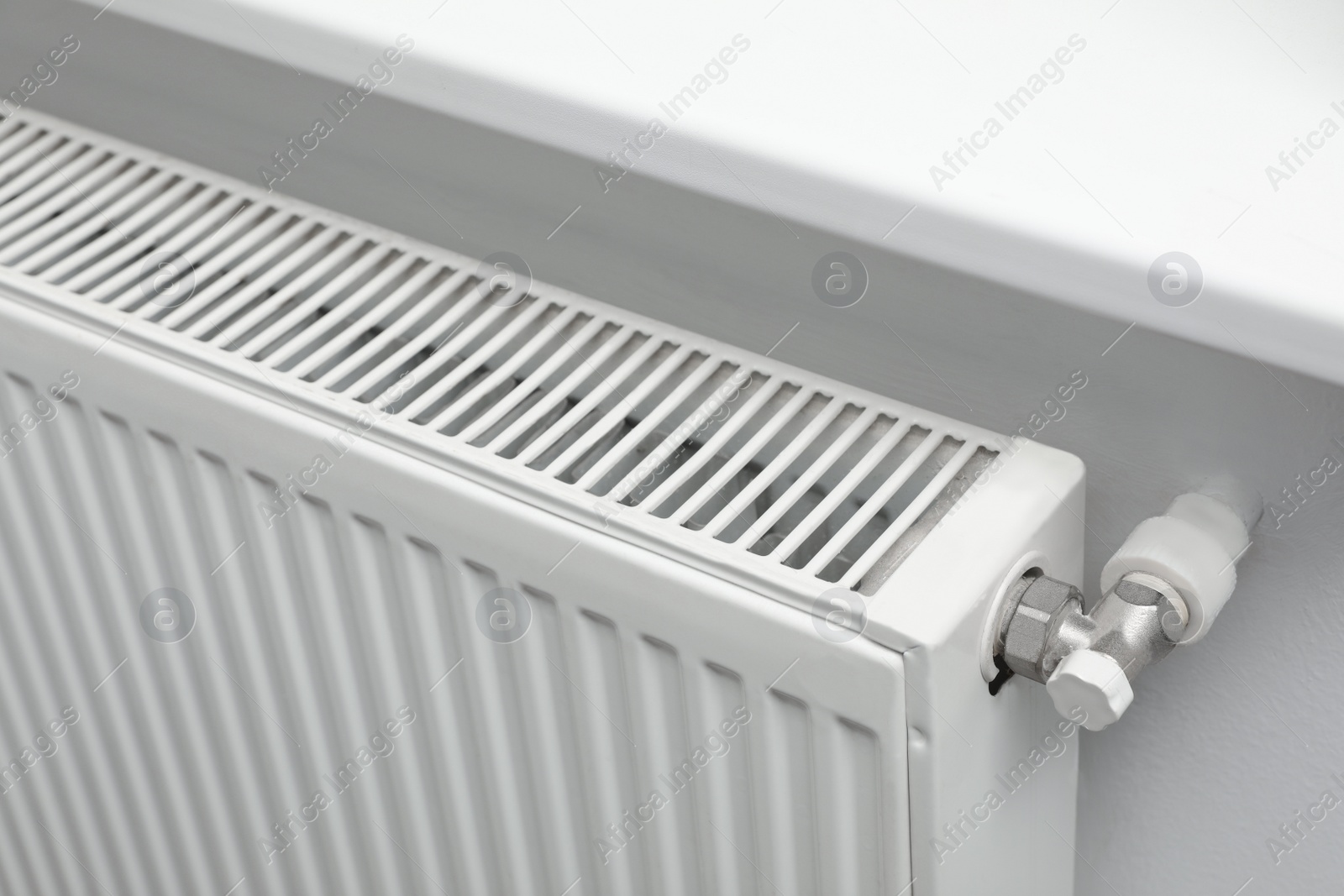 Photo of Closeup view of modern radiator. Central heating system