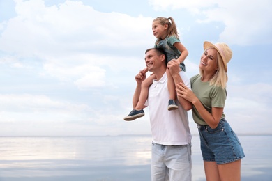 Photo of Happy family spending time together near sea on sunny summer day