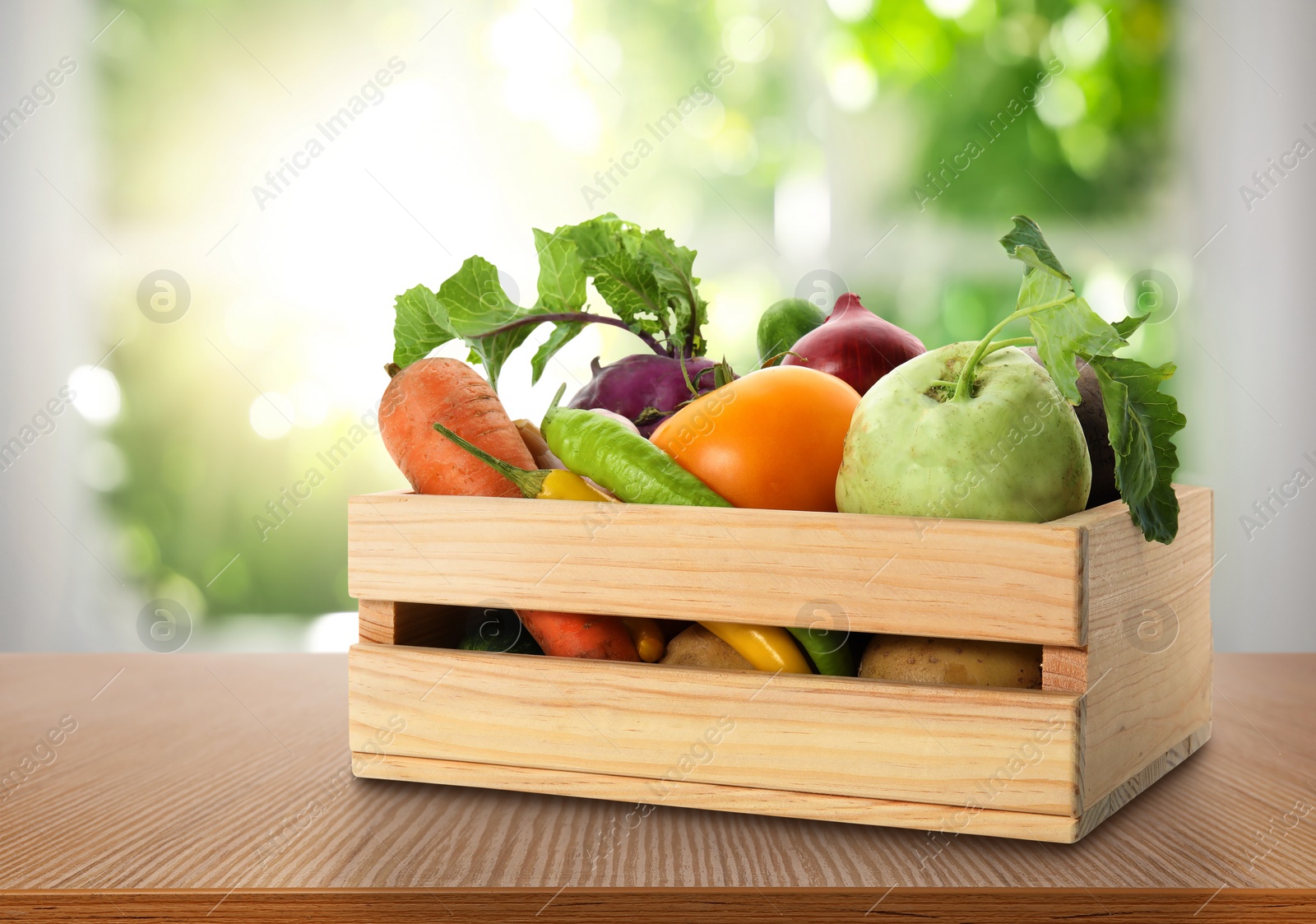 Image of Wooden crate with fresh vegetables on table in kitchen