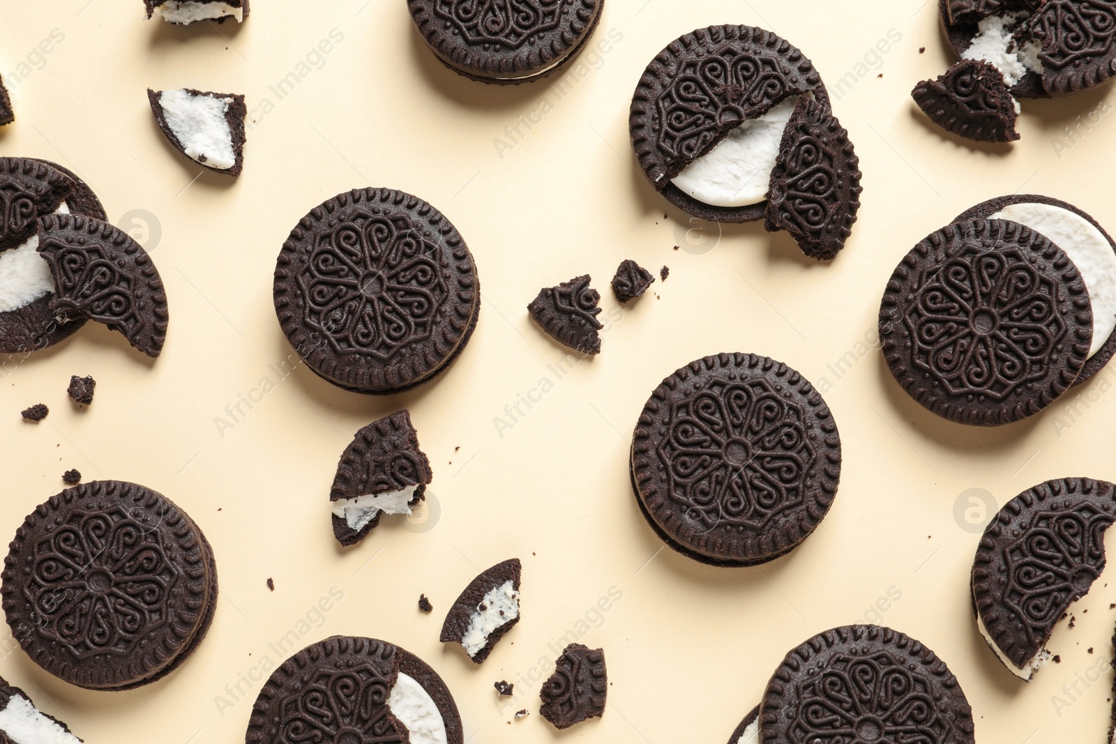 Photo of Tasty chocolate cookies with cream on color background, flat lay