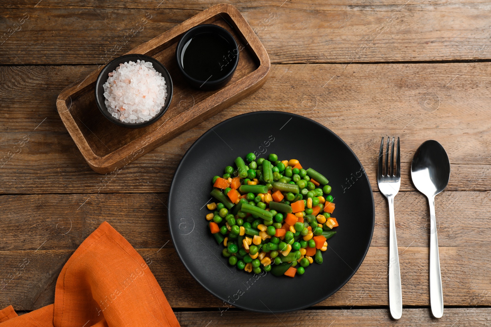 Photo of Mix of fresh vegetables served on  wooden table, flat lay