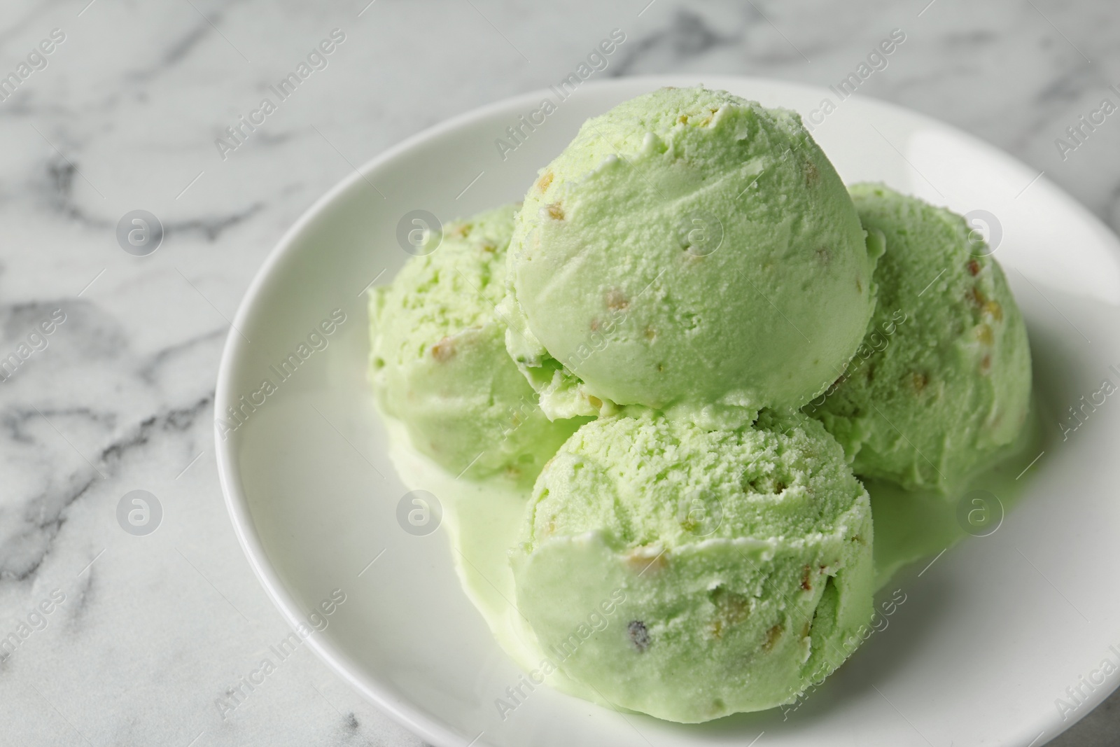 Photo of Delicious pistachio ice cream on marble table