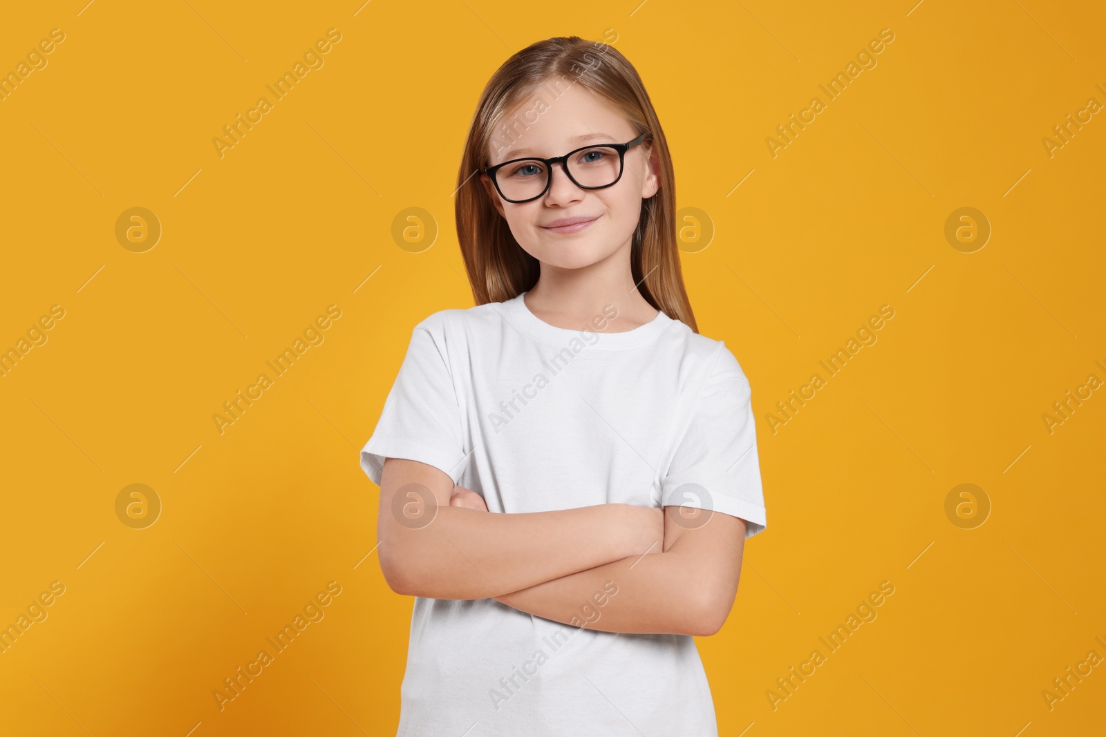 Photo of Portrait of cute girl in glasses on orange background