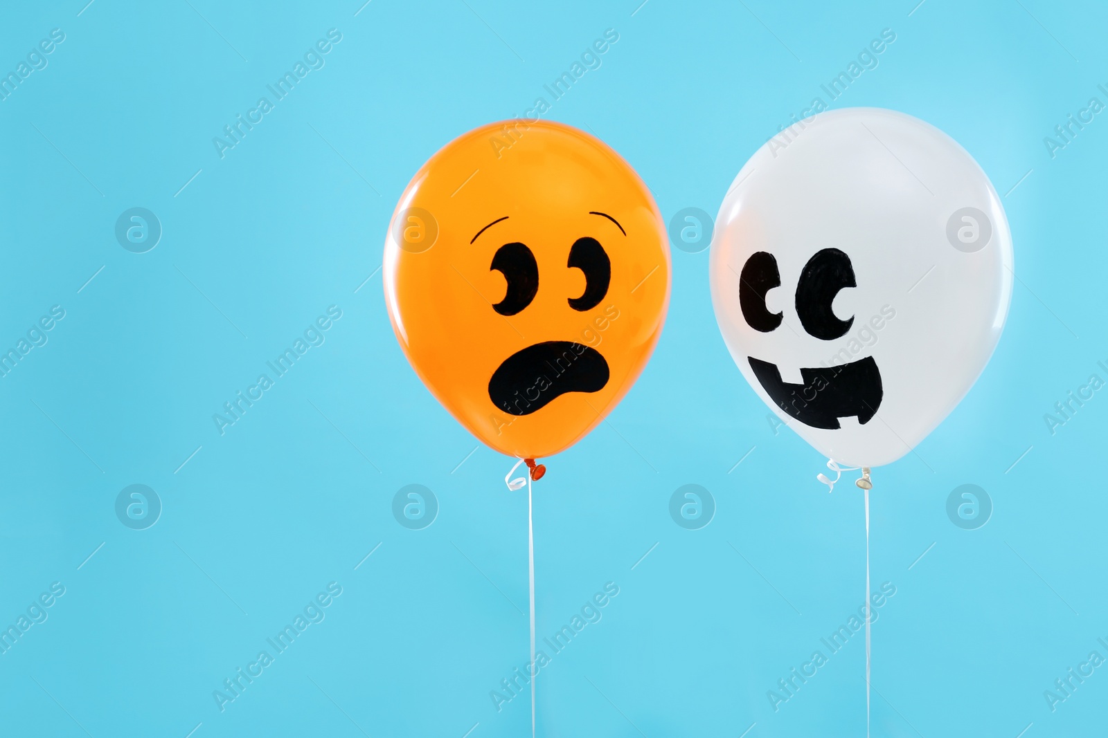 Photo of Colorful balloons for Halloween party on blue background, space for text