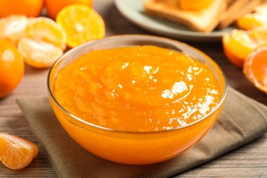 Delicious tangerine jam on wooden table, closeup