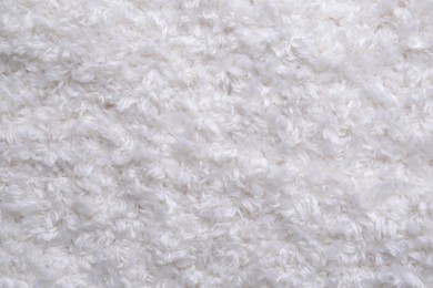 Soft white knitted fabric as background, top view