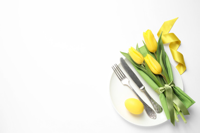 Festive Easter table setting with floral decor on white background, top view
