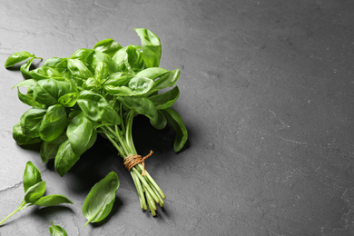 Photo of Bunch of fresh basil on grey table. Space for text