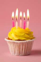 Photo of Tasty birthday cupcake with many candles on pink background, closeup
