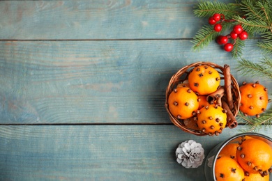 Flat lay composition with pomander balls made of fresh tangerines and cloves on wooden table, space for text