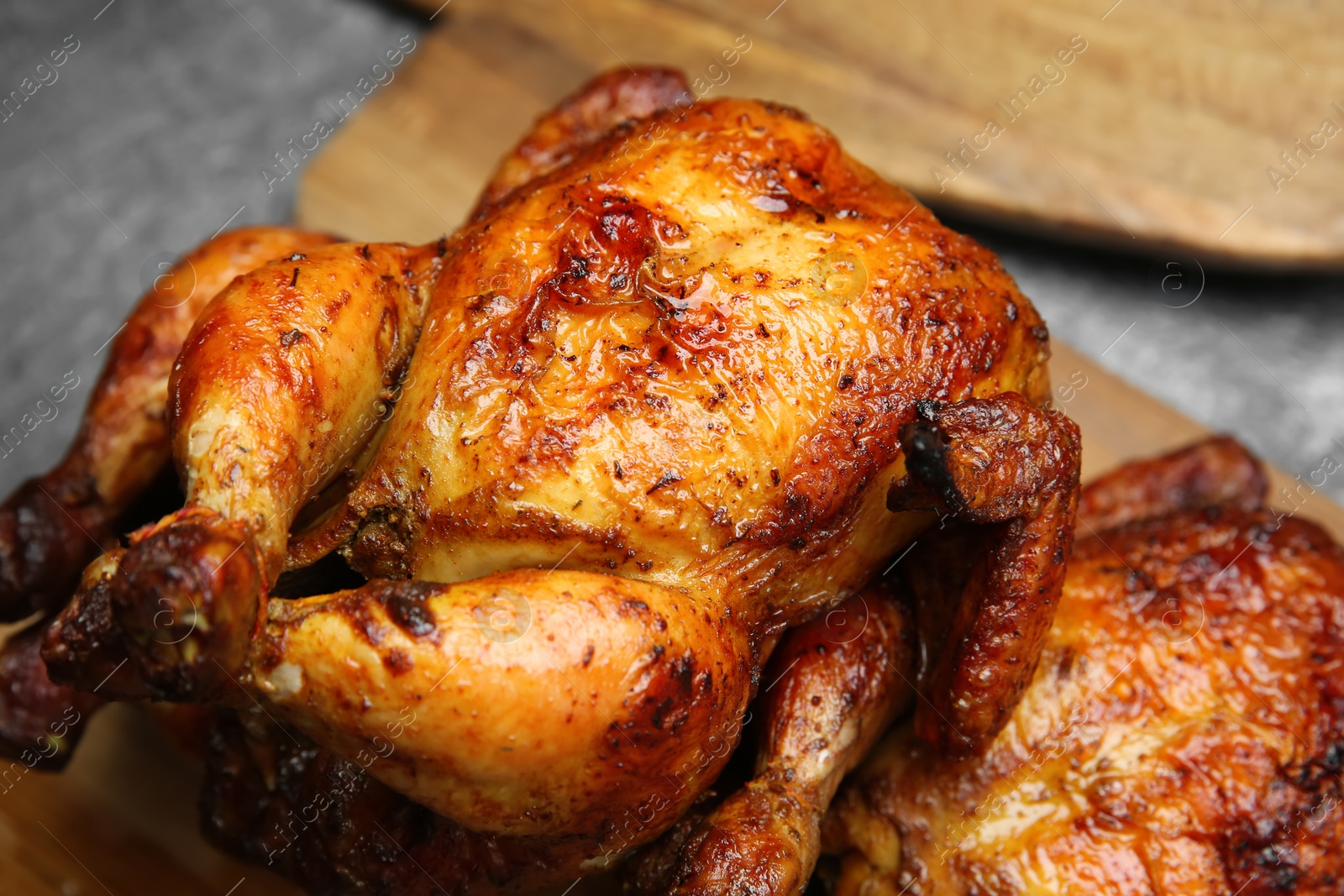 Photo of Delicious grilled whole chickens on grey table, closeup